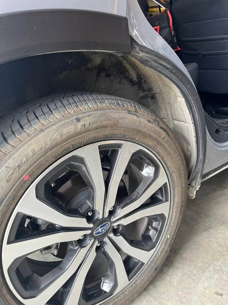 Truck tire and wheel well before cleaning, covered in dust and grime
